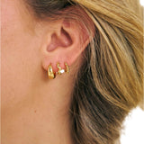 Girl wearing 3 18k gold filled huggie earrings 