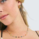 Model wearing rainbow necklace and coloured Carnival hoop earrings