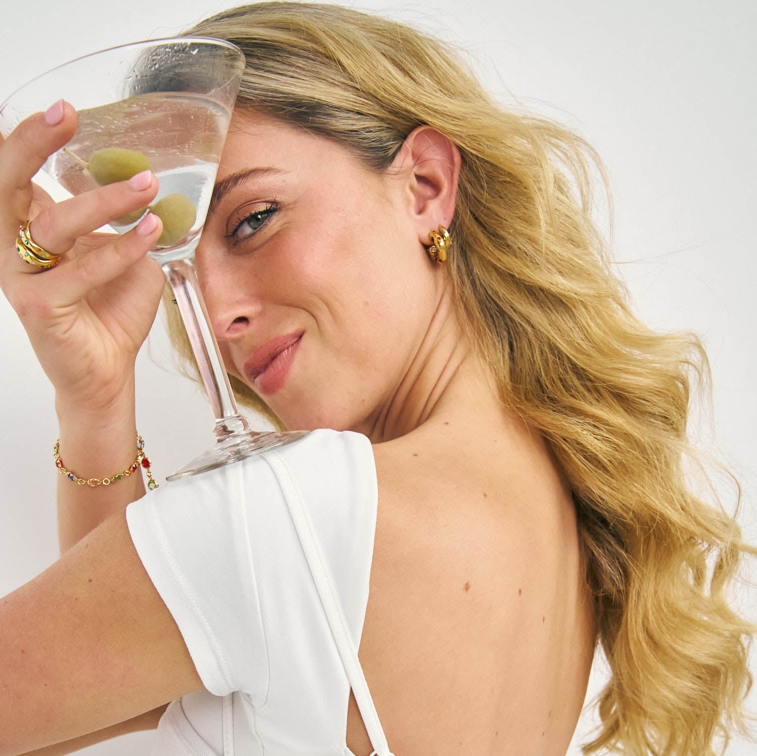 Firework earrings stack on a model holding Martini glass 