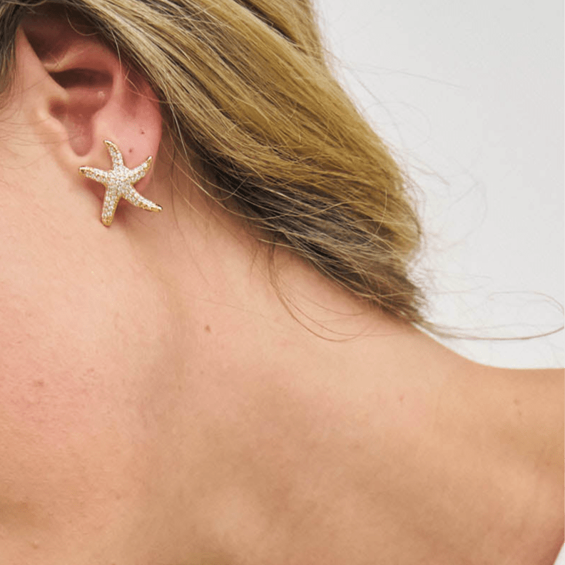 Crystal starfish shaped earrings on model 