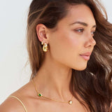 Model wearing Bottega shaped earrings with coloured gems